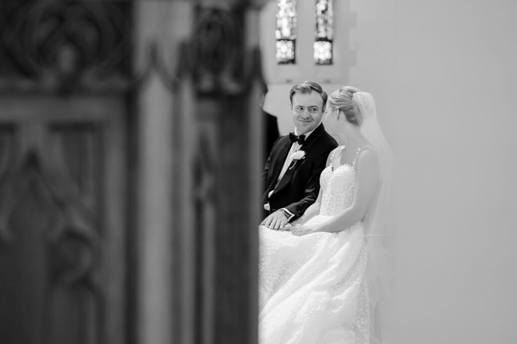 groom smiling at bride during Mass