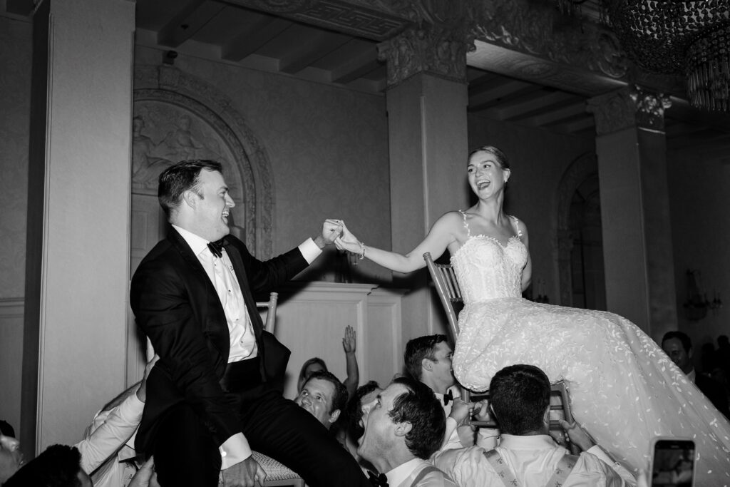 bride and groom lifted in chair on dance floor, 