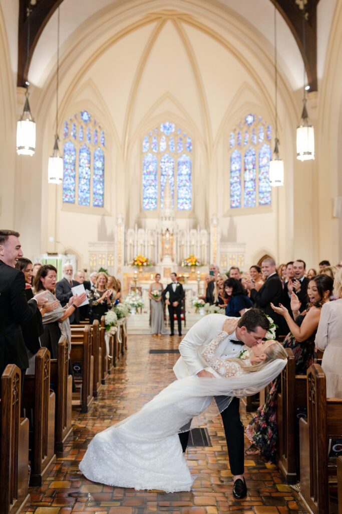 Groom and Bride kiss down the aisle after married