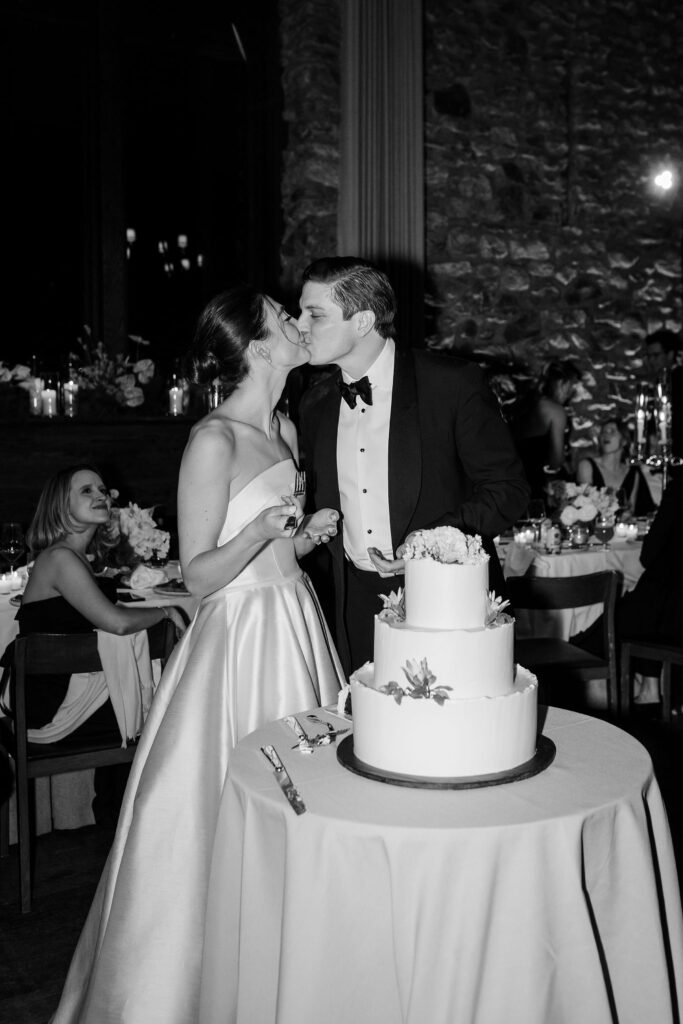 bride and groom cutting cake during wedding reception at Blue Hill at Stone Barns venue