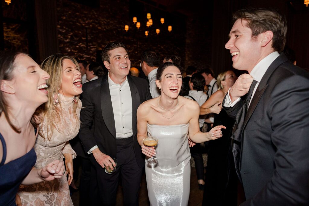 groom and bride and guests singing and laughing durning reception