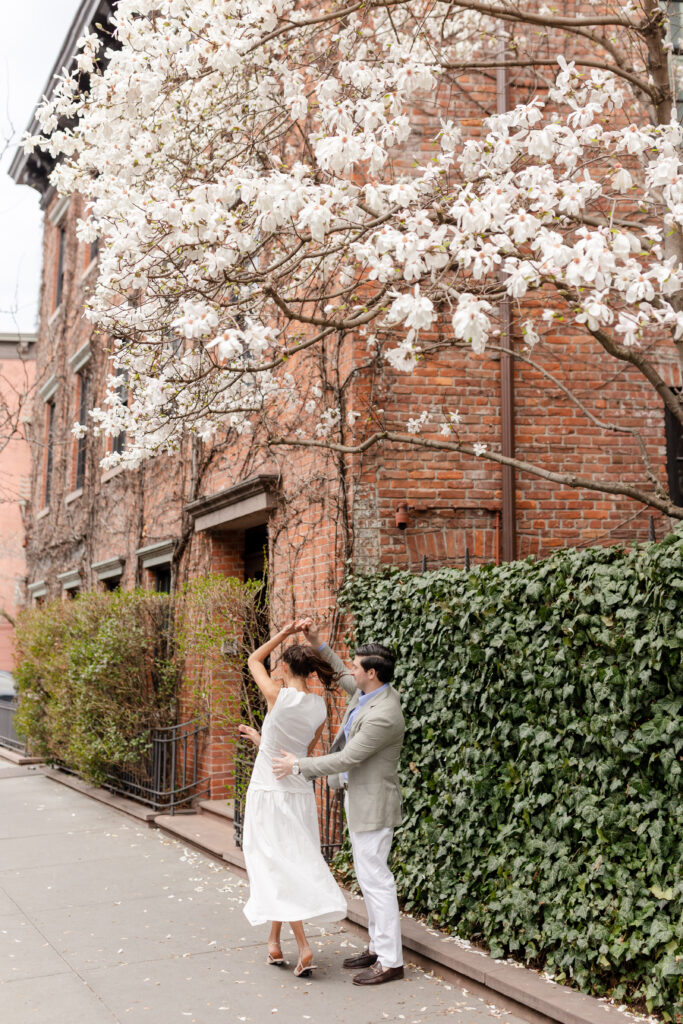 couple dancing in the street under spring blooms in West Village, top West Village engagement locations
