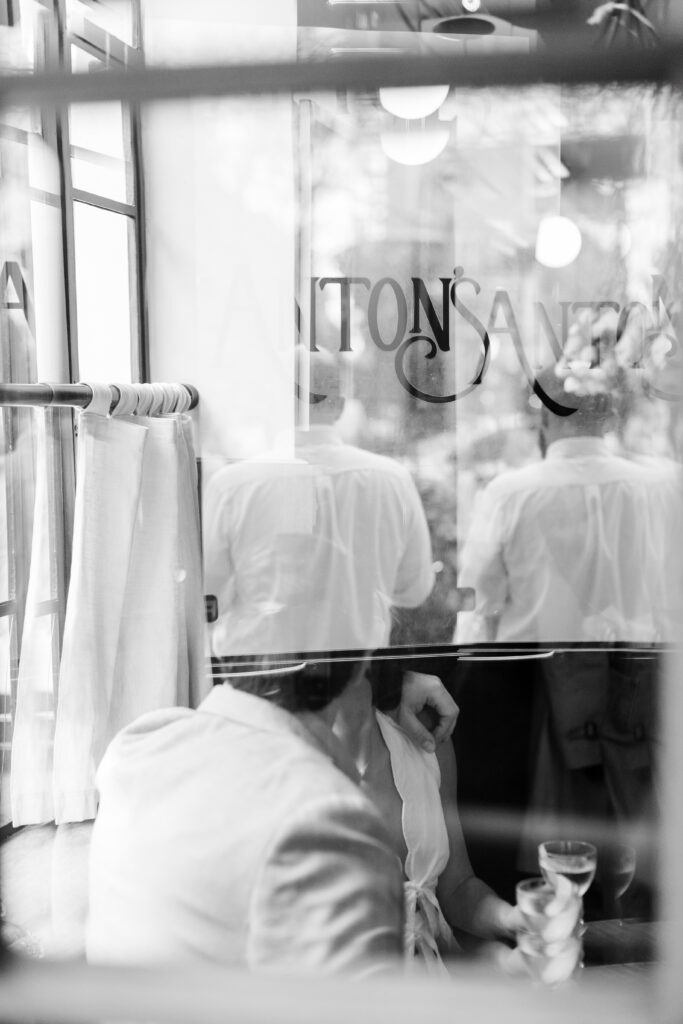 couple kissing at a table during engagement photos at Anton's, top West Village engagement locations