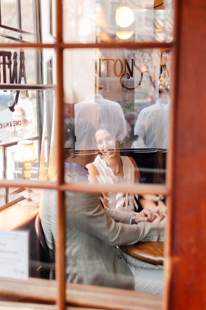 couple cuddling at a table during engagement photos at Anton's, top West Village engagement locations