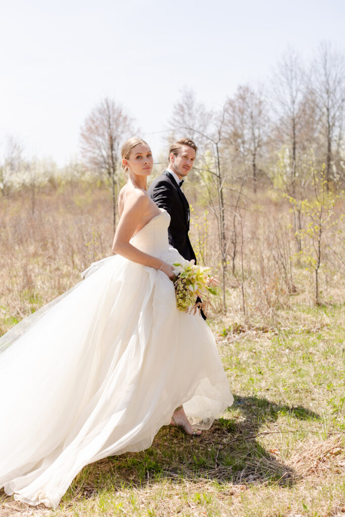 bride and groom walking in field at Wildflower Farms wedding venue in Hudson Valley