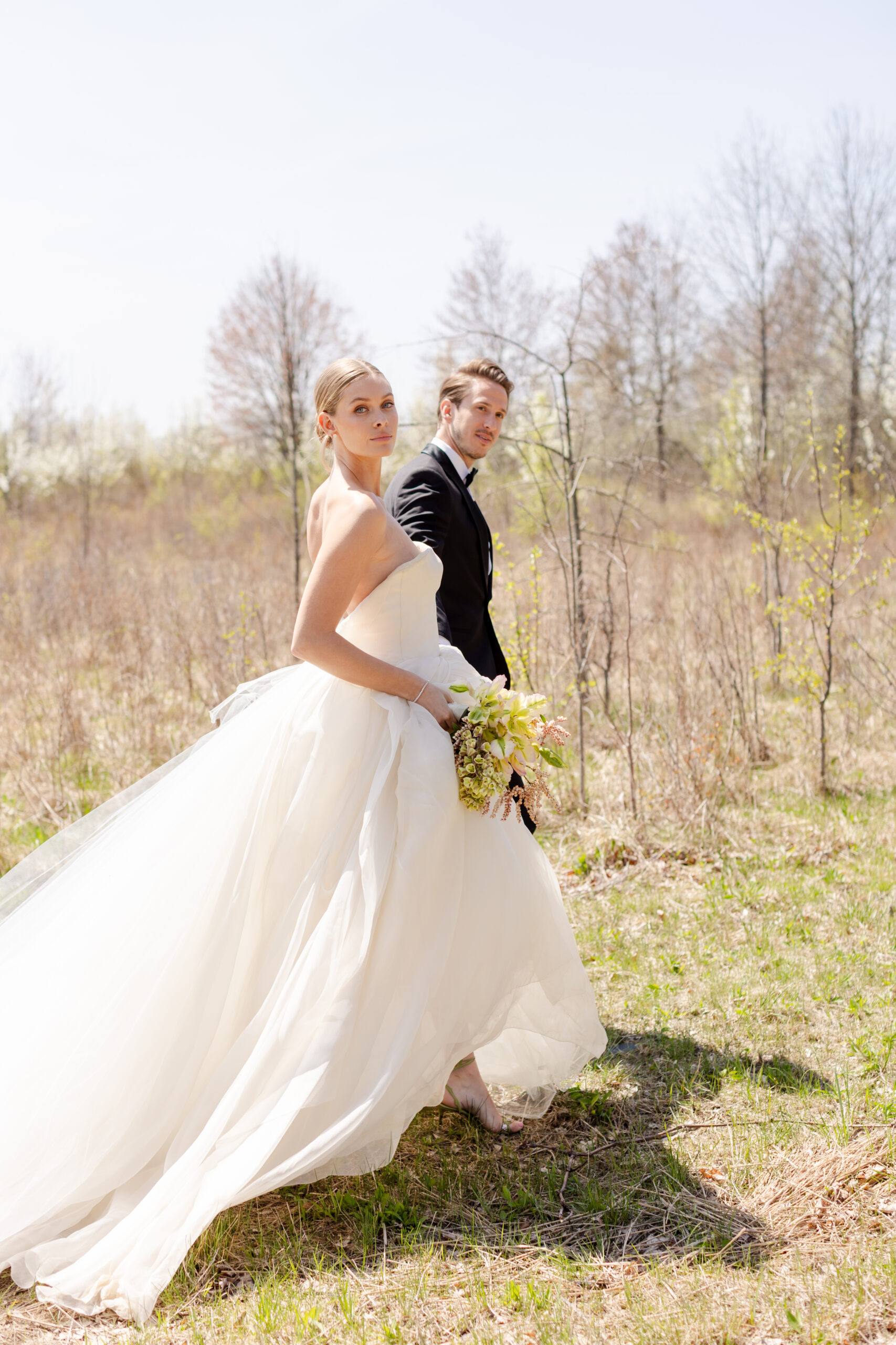 bride and groom walking in a field at Wildflower Farms in Hudson Valley