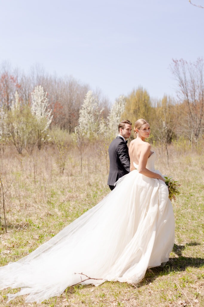 bride and groom walking in field at Wildflower Farms wedding venue in Hudson Valley