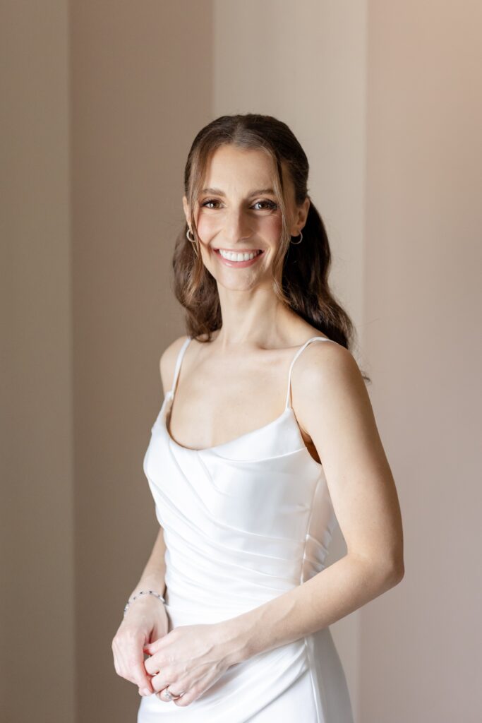 bride smiling durning bridal portraits in bridal suite at Westchester Country club