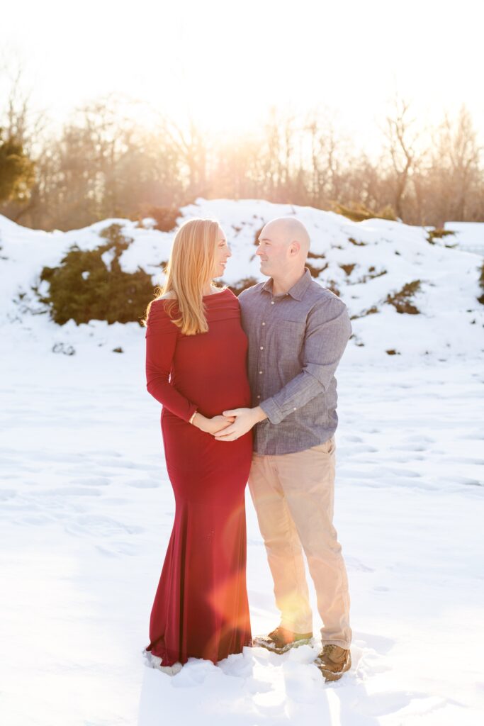 couple holding hands in snowy field at Harts Brook Park and Preserve in NY